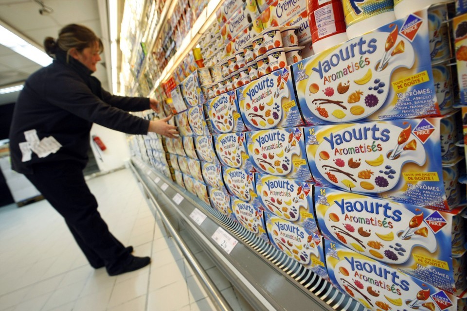Woman chooses between yogurts in supermarket