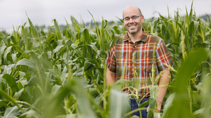 Dr. James Schnable standing in a field of corn. He is smiling. 